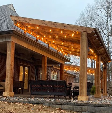 an outdoor covered patio with lights strung over it