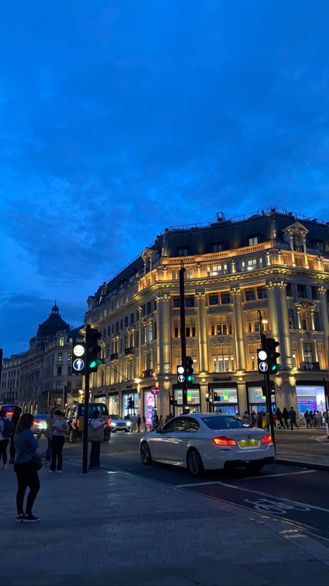 a busy city street at night with cars and people