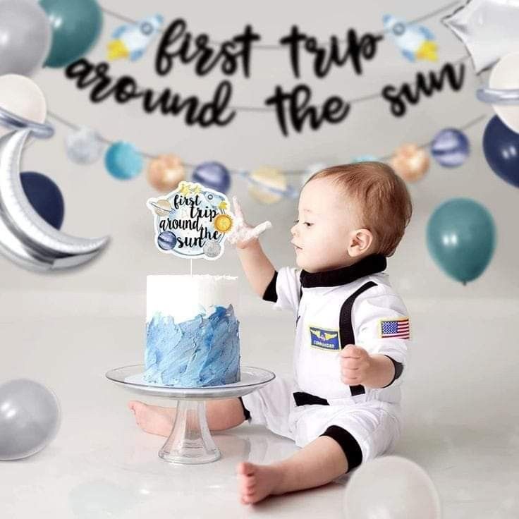 a baby boy sitting in front of a cake with the words best trip around the sun on it