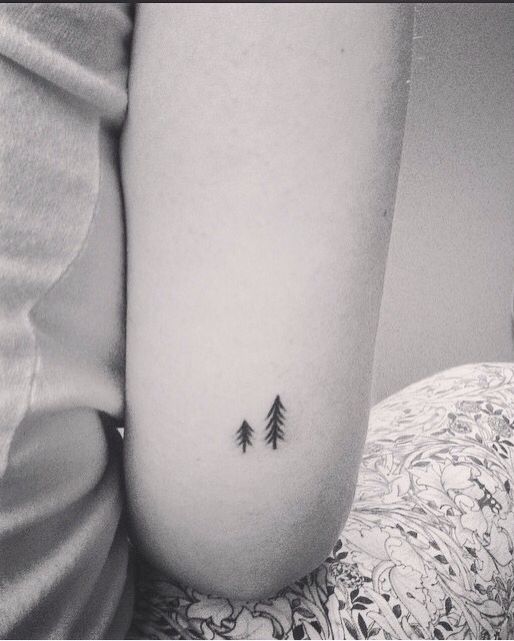 a small pine tree tattoo on the right side of the stomach, with an arrow in the middle