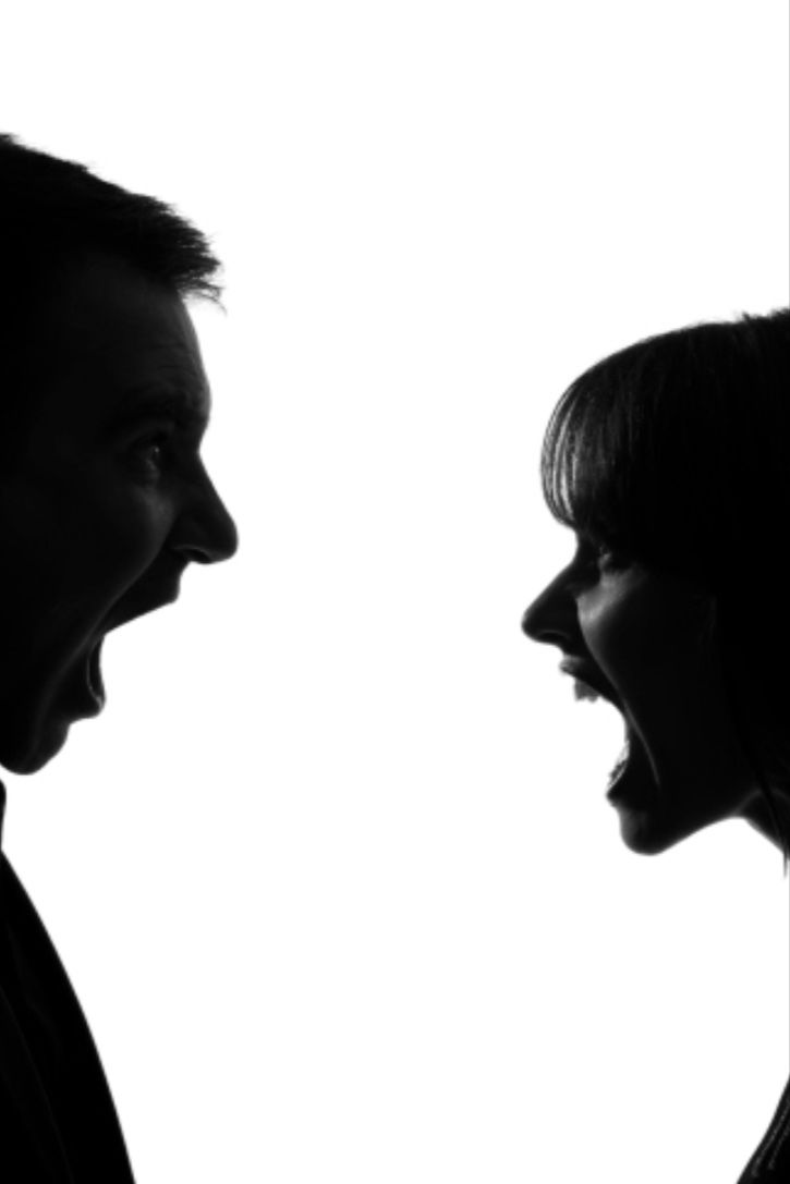 a man and woman face to face with each other in front of a white background