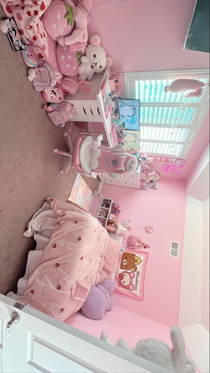 a pink room with stuffed animals on the wall and bedding in front of it