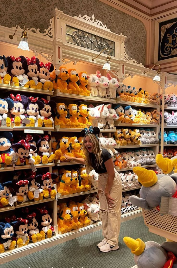 a woman standing in front of shelves filled with stuffed animals