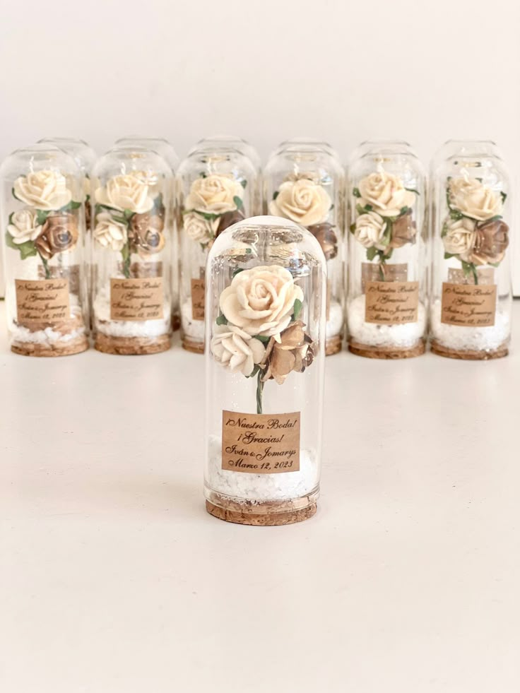 there are many glass jars with flowers in them and labels on the lids for each jar