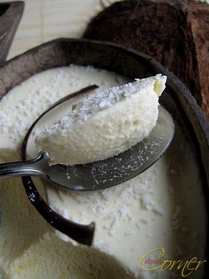 a spoon full of ice cream sitting on top of a bowl next to some bread