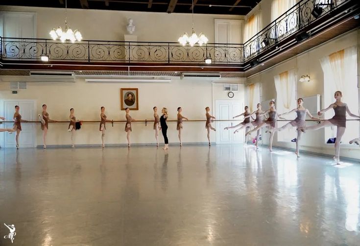 a group of ballet students practicing in a large room