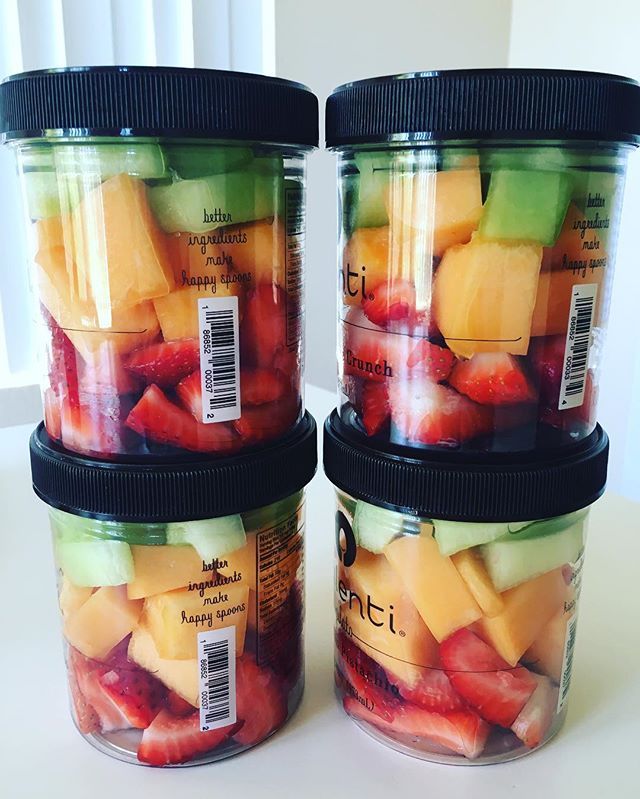 two jars filled with sliced fruit sitting on top of a table next to each other