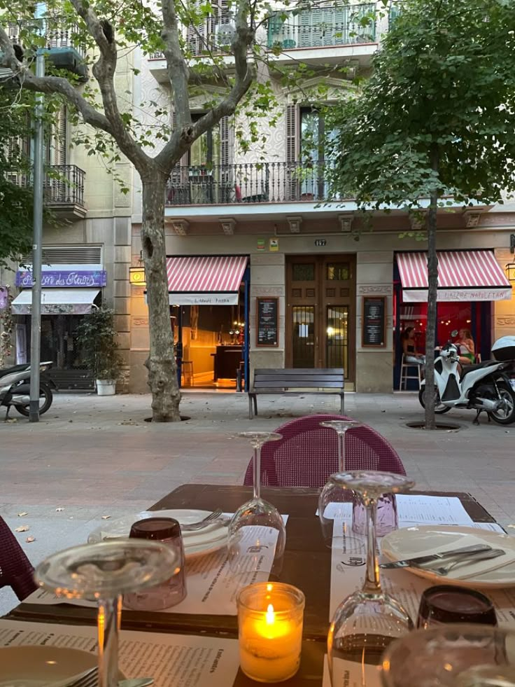 an outdoor dining area with tables, chairs and scooter parked in the background