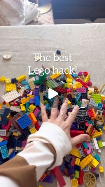 a child's hand reaching for legos on a table with the words, the best lego hack