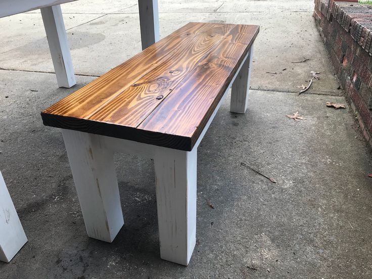 a wooden bench sitting on top of a sidewalk