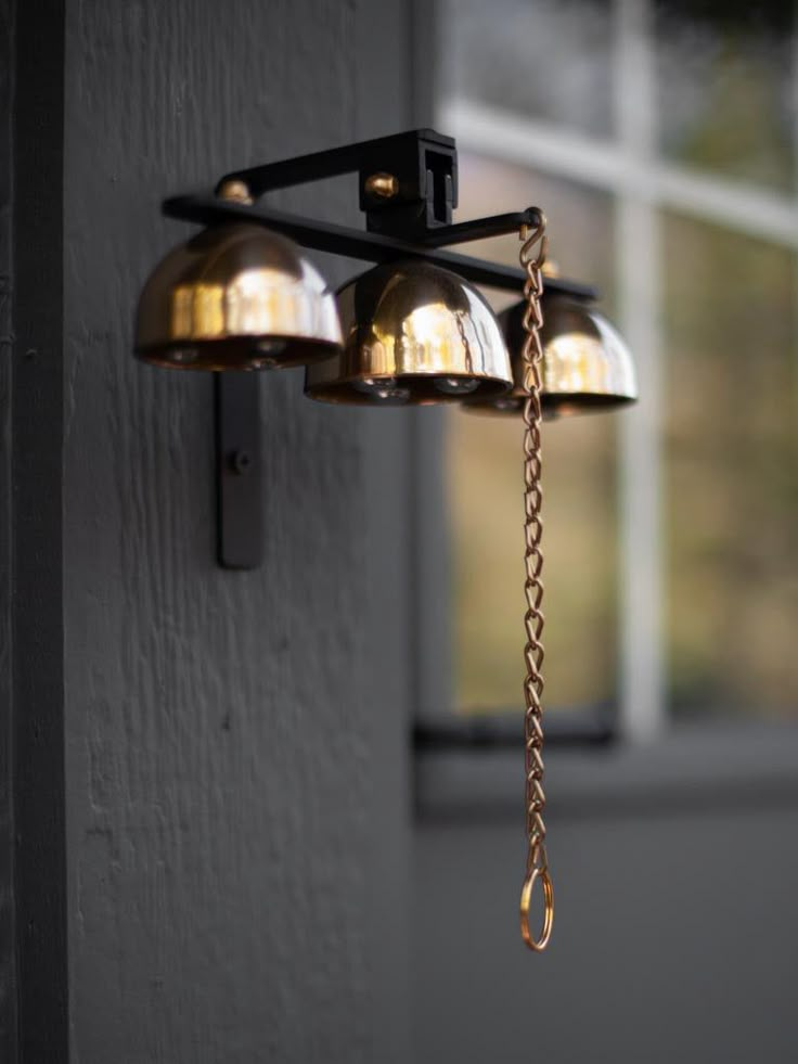 three bells hanging from the side of a building