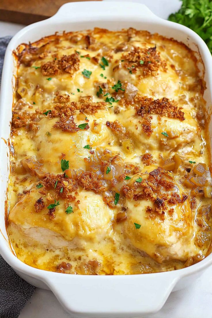 a casserole dish with meat and cheese in it on a white plate next to parsley