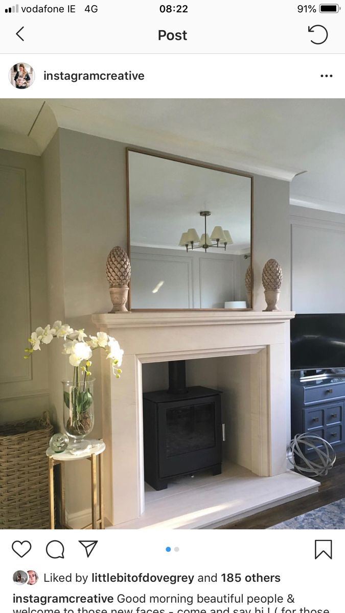 an instagramted photo of a fireplace in a living room with mirrors on the mantle