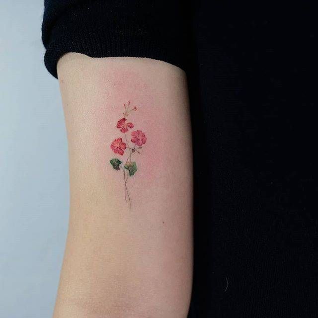 a small flower tattoo on the arm