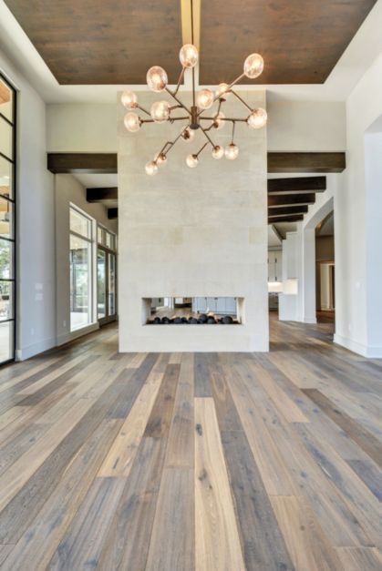 a large white room with wooden floors and a chandelier hanging from the ceiling