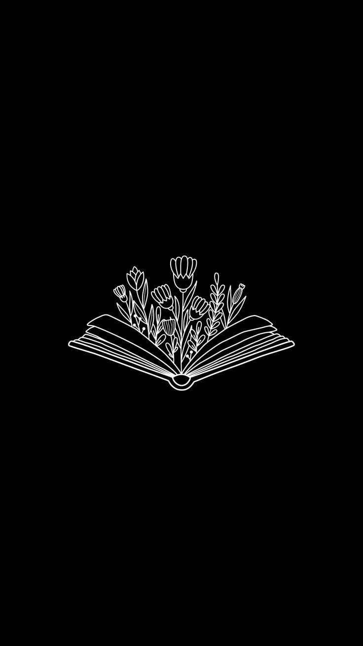 an open book with flowers on it in black and white, against a dark background