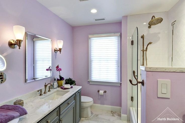 a bathroom with purple walls and marble counter tops