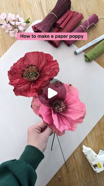 someone is making paper poppys on the table