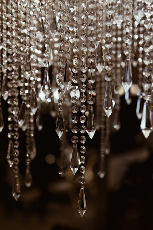 a chandelier hanging from the ceiling with lots of crystal beads attached to it