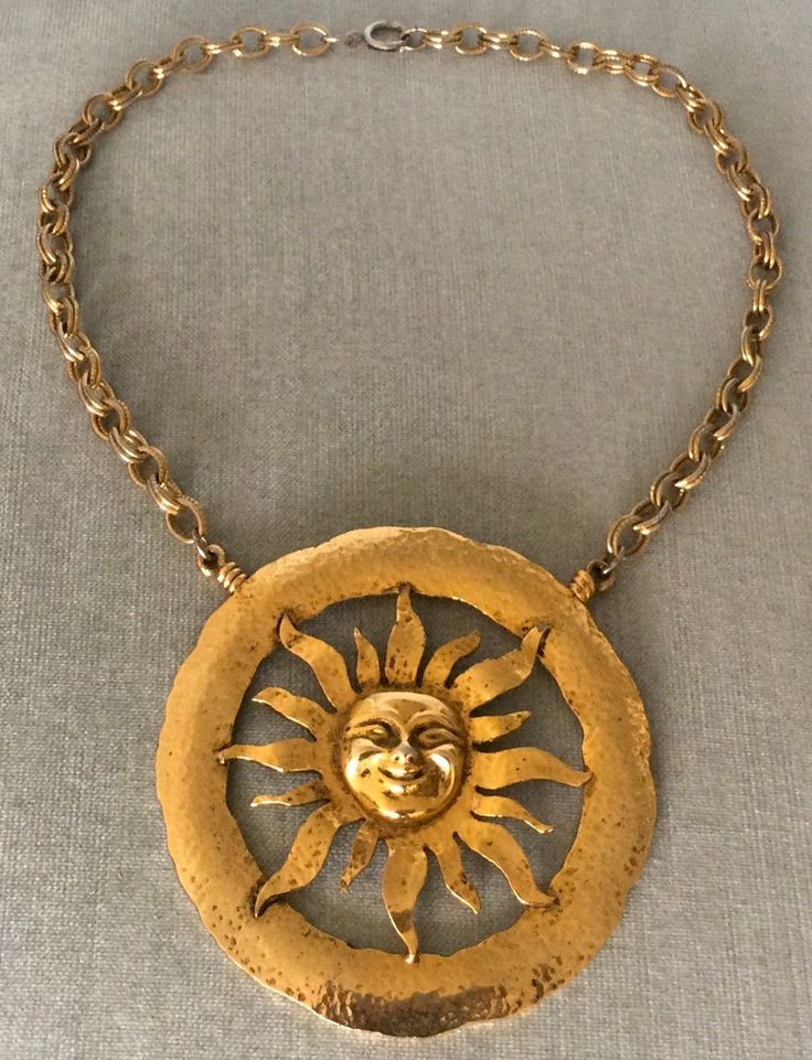 You are looking at a truly spectacular VINTAGE TORTOLANI MID CENTURY MODERNIST MASSIVE ALMOST 4" SUN FACE EXTRA BIG SCULPTURAL DIMENSIONAL ROUND MEDALLION PENDANT BREASTPLATE BIB ON CHAIN CHOKER COLLAR NECKLACE, completely done in Rich Gilt Gold-tone Metal, with an Avant-garde chic look reminiscent of Elsa Schiaparelli, SIGNED, Circa 1970's. VERY REPRESENTATIVE OF THE MID CENTURY MODERNIST CELESTIAL INSPIRED CREATIONS, THIS NECKLACE IS EXQUISITE IN ITS DESIGN AND IT WILL LOOK STUNNING WHEN BEING WORN FEATURING A MASSIVELY HUGE HAMMERED GOLD METAL ROUND MEDALLION CENTERPIECE THAT IS JUST SHY OF 4" IN DIAMETER, THIS SCULPTURAL CELESTIAL INSPIRED SUN CREATION IS JUST GORGEOUS IN ITS DESIGN, SHOWCASING REMARKABLE DIMENSIONAL DETAILS ON THE FACE AND THE RAYS OF THE SUN ITSELF, WHICH IS FRAMED B Schiaparelli Couture Vintage, Sun Medallion, Vintage Schiaparelli, Schiaparelli Couture, Choker Necklace Gold, Choker Collar Necklace, Sun Face, Rays Of The Sun, Sun Necklace