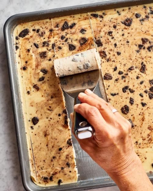 someone using a spatula to spread the batter on top of an unbaked cake