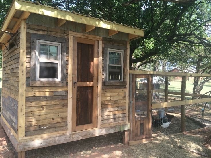 a small wooden shed with a chicken coop