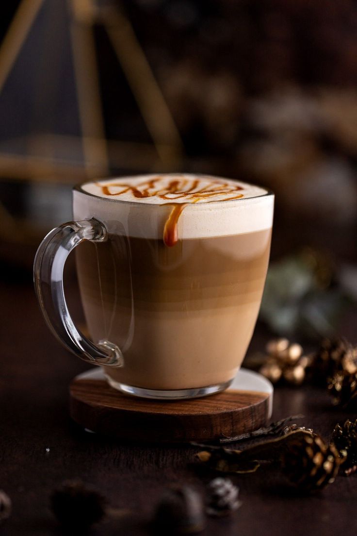 a cappuccino is sitting on a wooden coaster