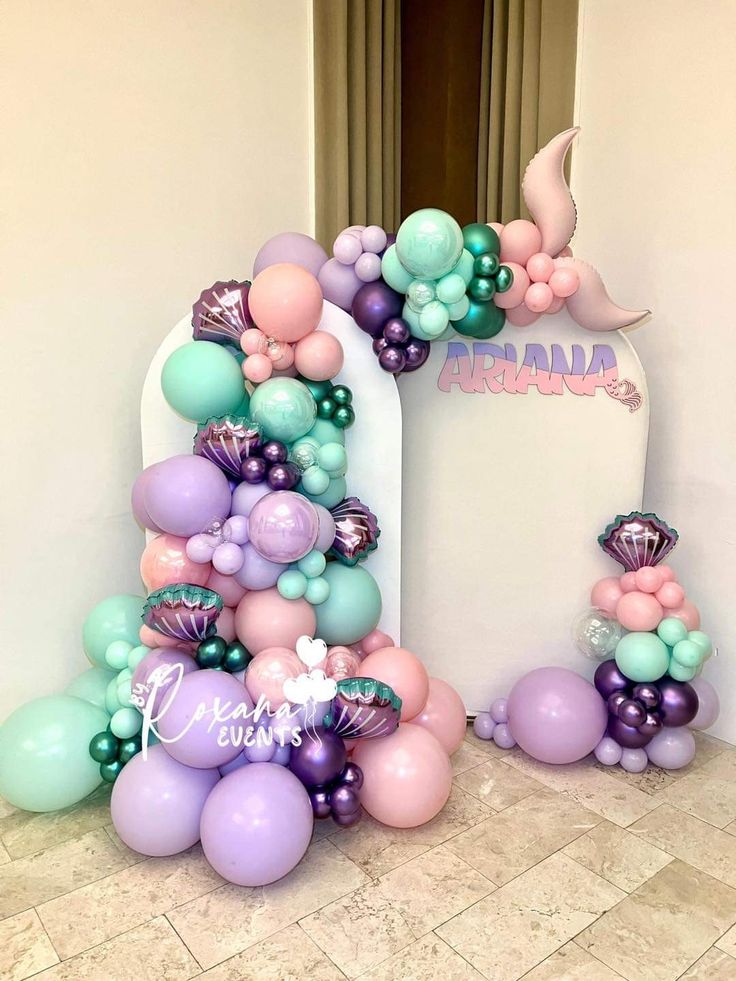 the balloon arch is decorated with mermaid balloons