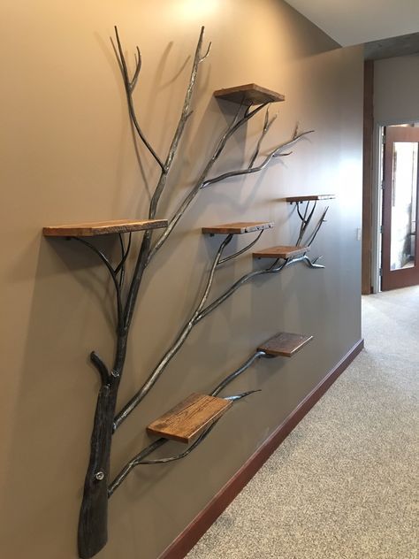 a metal tree with wooden shelves on the wall