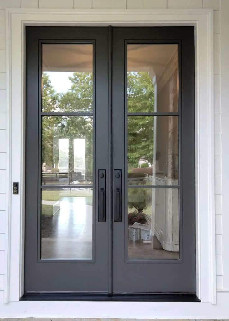 the front door to a house with two double doors and glass panels on each side