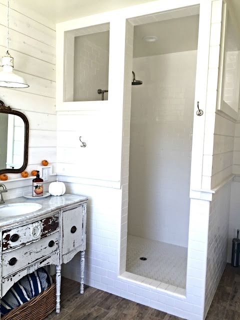 a bathroom with white walls and wood floors