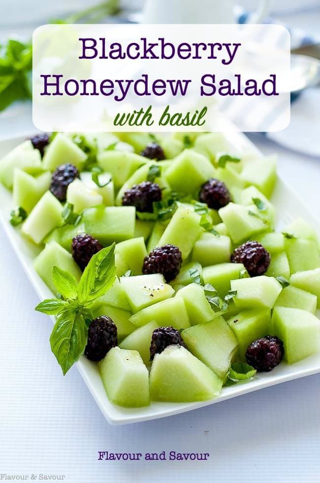 blackberries and honeydew salad with basil on a white platter, ready to be eaten