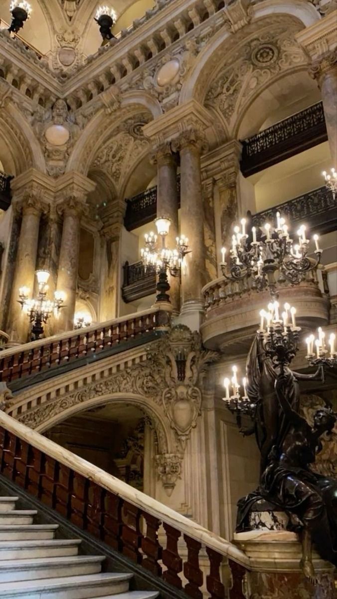 an ornate staircase with chandeliers and statues