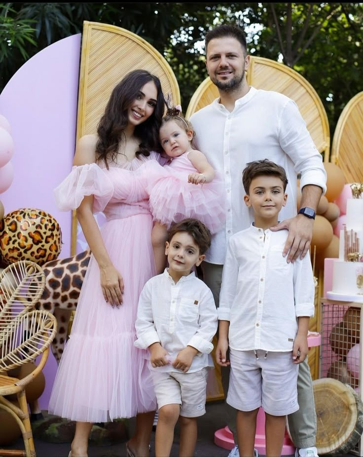 a family poses for a photo in front of an animal themed backdrop