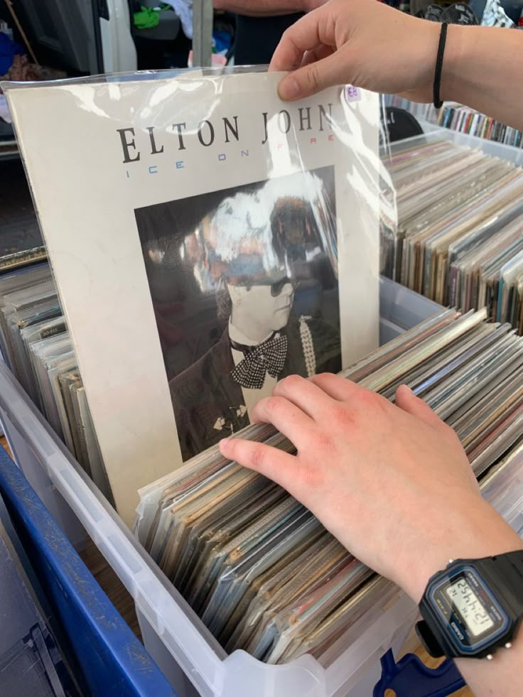 a person reaching for a record in a bin