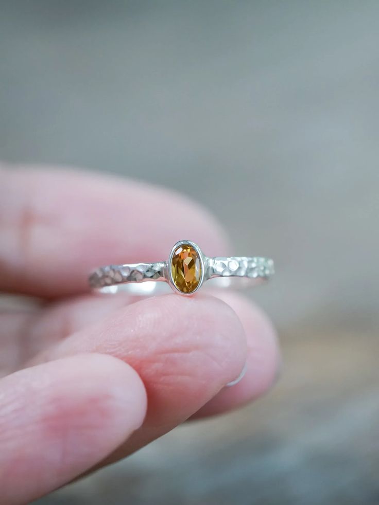 This oval citrine ring rings in a festive and glowing spirit. Set in a bezel setting with a vibrant yellow-orange citrine sourced from Brazil. The silver band has a hammered texture, which adds both shine and dimension. Citrine is a November birthstone. Each piece of our jewelry is handcrafted with love. This rustic citrine ring will add a touch of festivity to your everyday look. Amber Topaz Sterling Silver Promise Ring, Amber Topaz Ring In Sterling Silver For Promise, Amber Topaz Sterling Silver Ring, Silver Citrine Birthstone Ring Gift, Sterling Silver Amber Birthstone Rings, Reminder To Yourself, Orange Citrine, Gold And Silver Rings, Ring Birthstone