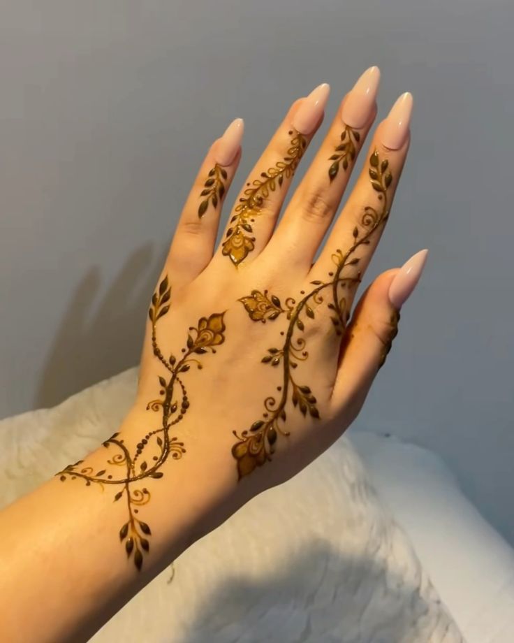 a woman's hand with henna tattoos on it