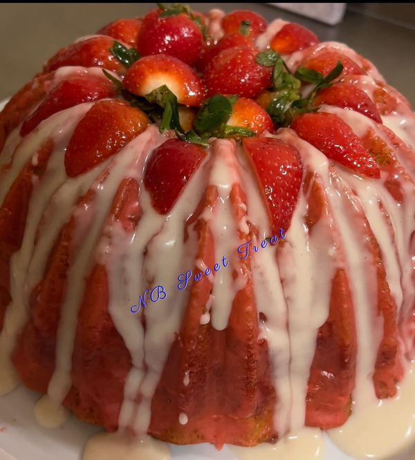 a strawberry bundt cake with icing and strawberries on top