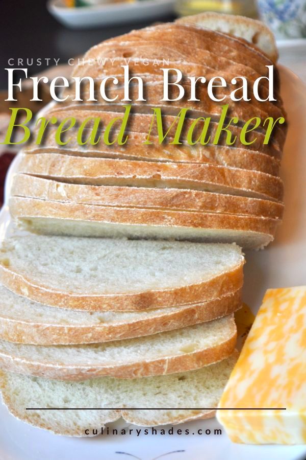 french bread sliced up on a plate with butter and crackers next to it in the background