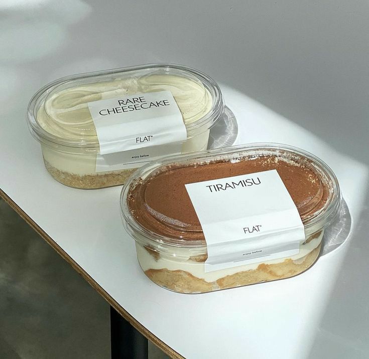 two desserts with labels on them sitting on a table