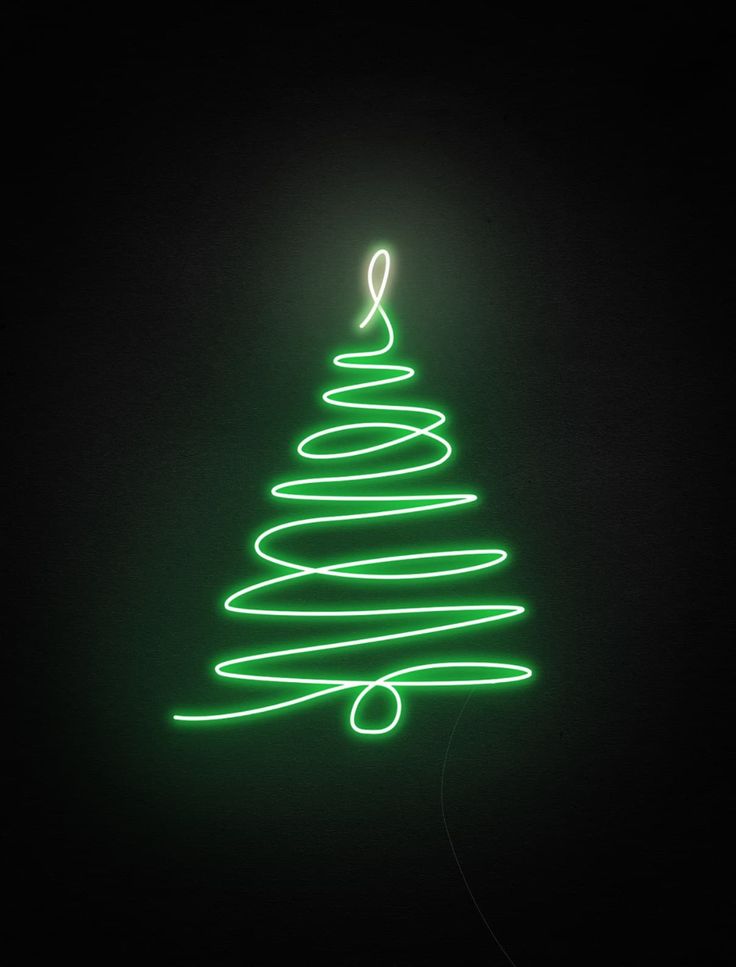 a green christmas tree is lit up in the dark, with light streaks on it