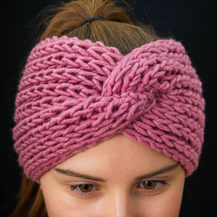 a close up of a woman wearing a knitted headband and looking at the camera