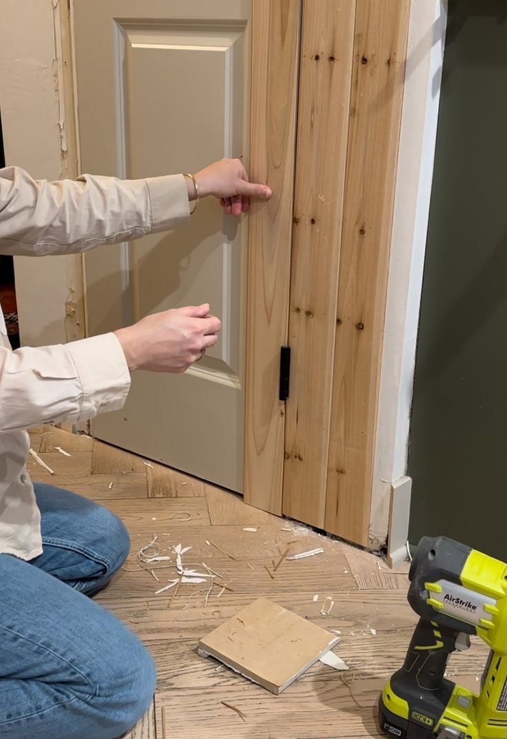 a woman sitting on the floor with a hammer and screwdriver in front of her