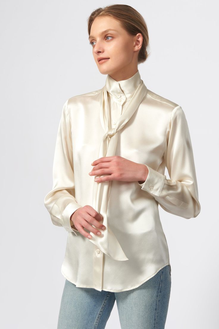 Our best-selling Scarf Tie Blouse is always a fan favorite. Made in beautiful Silk Charmeuse with a removable scarf, this style is a go to for any sophisticated day or evening event; a must-have for every woman's wardrobe. Removable scarf with back loop detail, stand collar, front closure with mother of pearl buttons, classic cuff construction with adjustable width closure, and a buttoned sleeve placket. - 100% Silk - Made in NYC - Dry clean only - Our model is 5'9.5" wearing size S - Chest Widt Tie Blouse Outfit, Cream Satin Blouse, Silk Shirt Outfit, Capsule Wardrobe Pieces, Scarf Tie, Sleeve Placket, Casual Outfits For Women, Business Casual Outfits For Women, Neck Cream