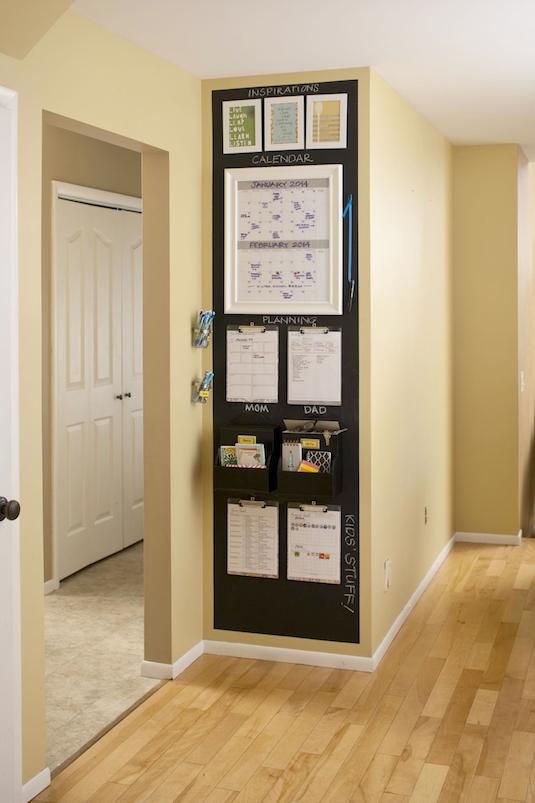 a wall hanging organizer in the corner of a room next to a door with sticky notes on it