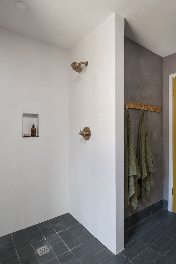 a bathroom with two towels hanging on the wall and a yellow door in the background