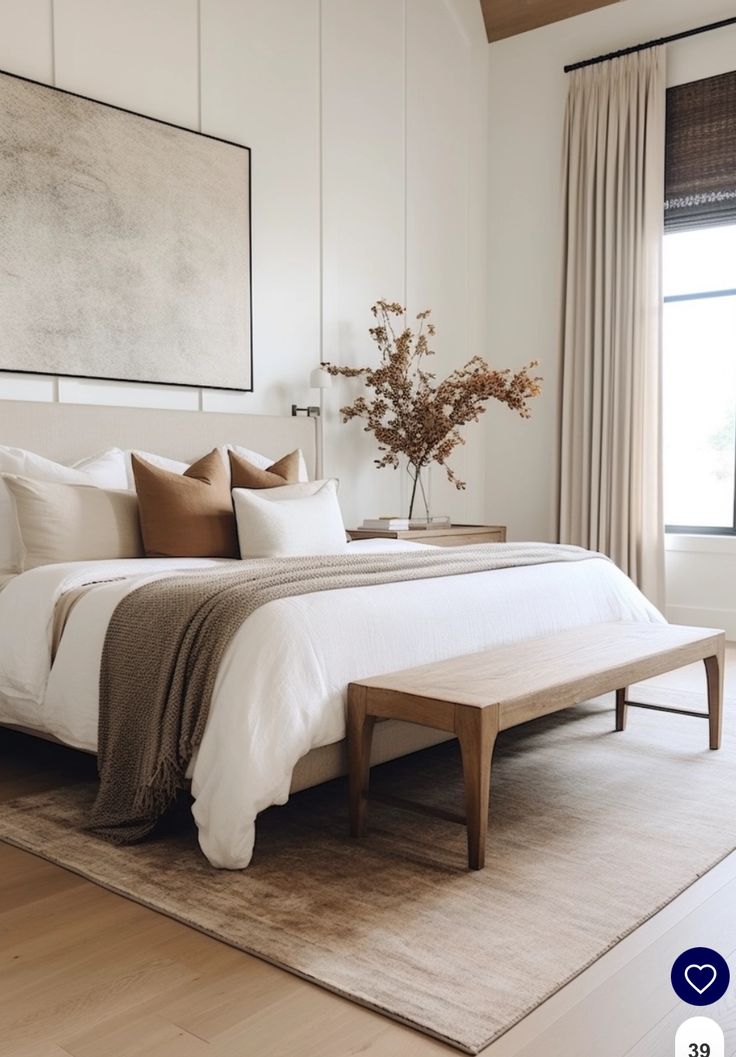 a bed with white sheets and pillows in a bedroom next to a large painting on the wall