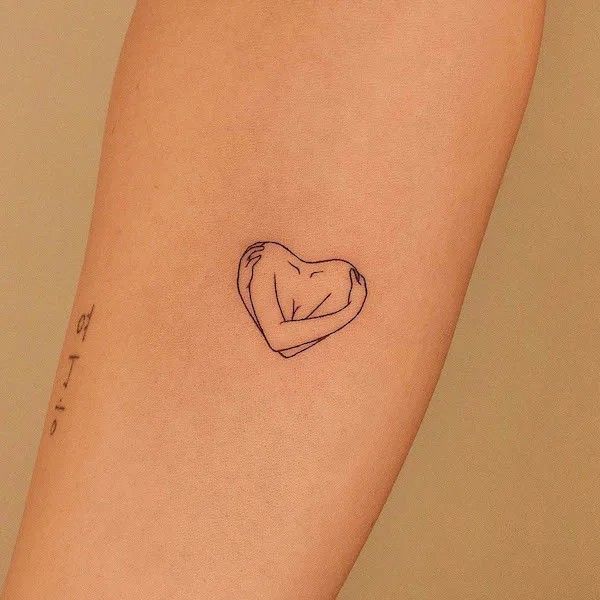 a small heart tattoo on the arm