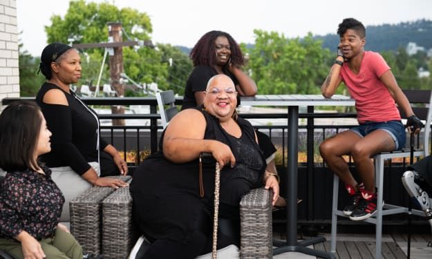 a group of women sitting on top of chairs