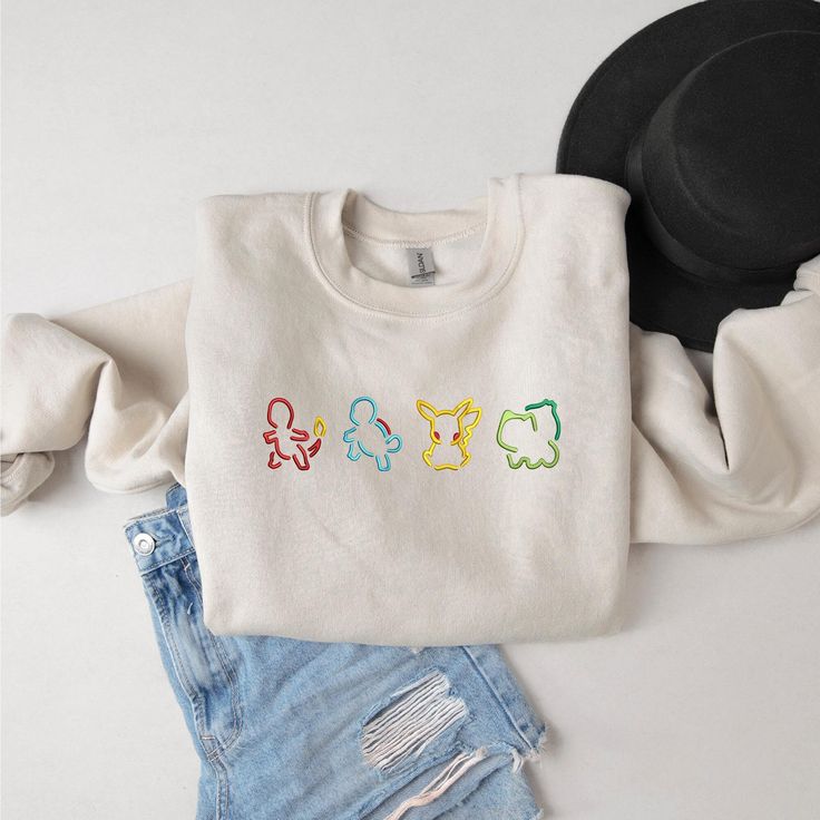 Bring a touch of nostalgia to your wardrobe with this Embroidered Vintage Cartoon Sweatshirt! Perfect for fans of classic cartoons, this retro-inspired crewneck features your favorite characters like Pikachu, Squirtle, Bulbasaur, and Charmander. The detailed embroidery adds a unique, stylish touch, making this sweatshirt a must-have for both casual wear and collector's items. Ideal as a gift for him, this cozy pullover is made from premium fabric, ensuring comfort and durability. Whether you're Embroidery Pokemon Patterns, Embroidered Pokemon, Pokemon Silhouette, Aesthetic Pokemon, Pokemon Embroidery, Pokemon Sweatshirt, Pokemon Shirt, Casual Luxe, Vintage Cartoons